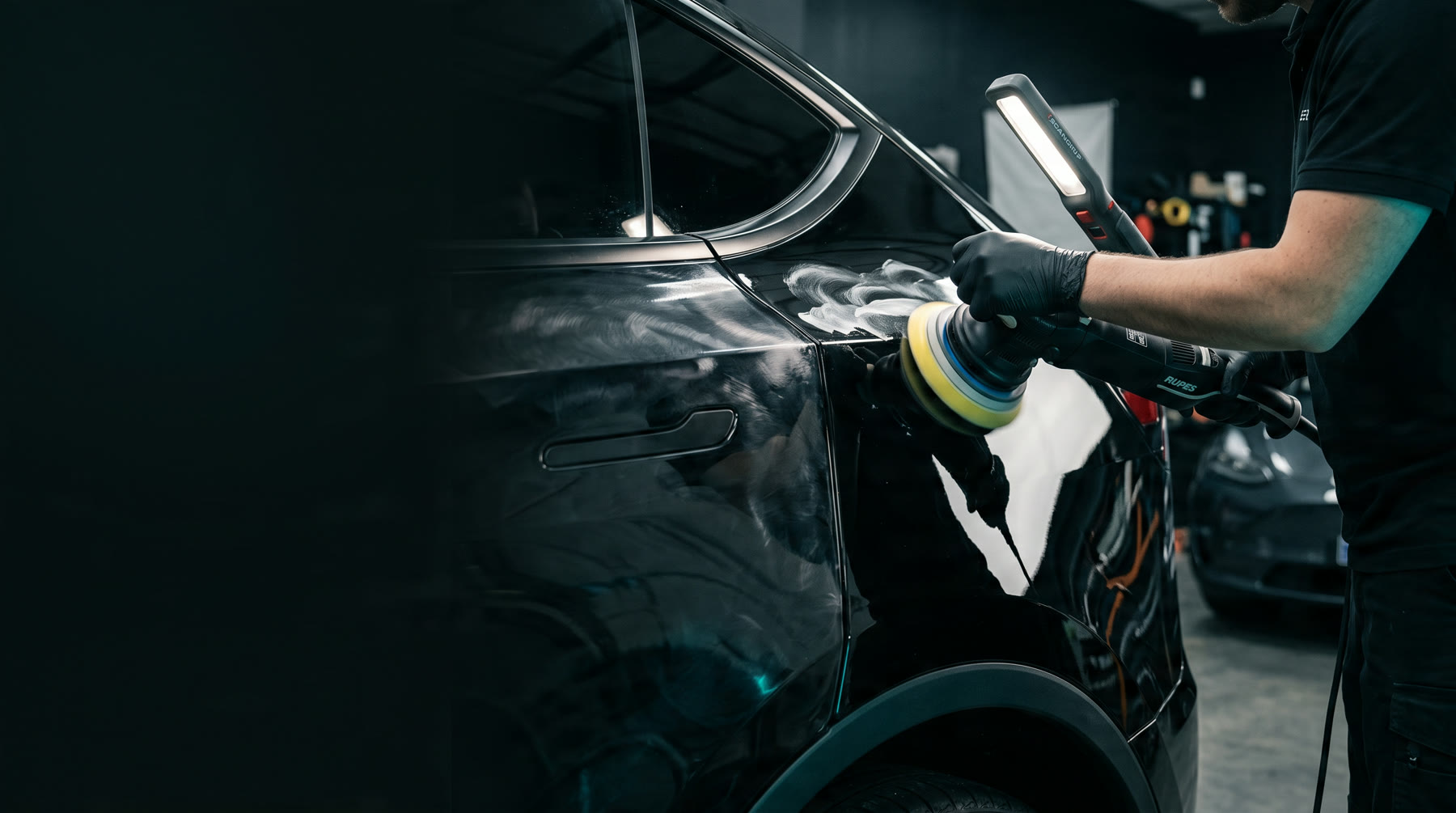 Polisher cutting defects out of gloss-black paint